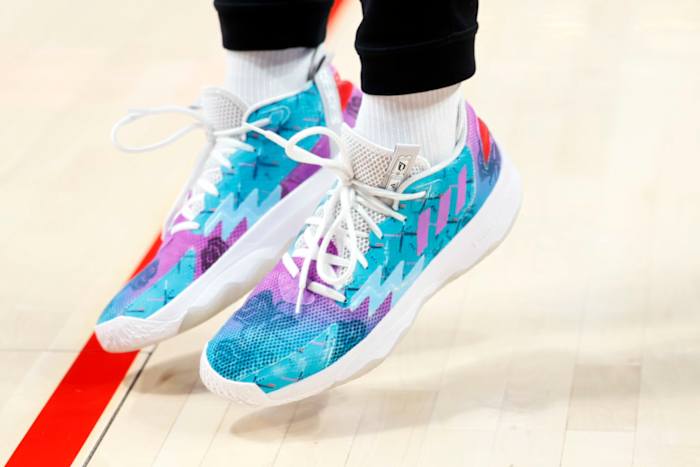 View of teal, purple, and white adidas shoes.